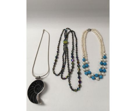 A large shell necklace on a silver chain, a carnival necklace and a pearl &amp; turquoise necklace.