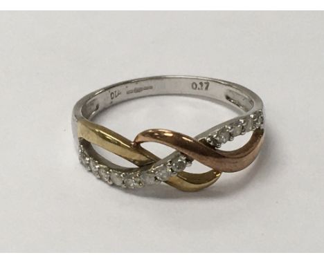 A gold 9ct three tone ring set with 0.17ct diamonds. Weighing approximately 2.3g and measuring approximately ring size o.