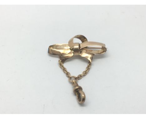 An unmarked gold brooch in the form of a ribbon tie bow, approx 3.5g.