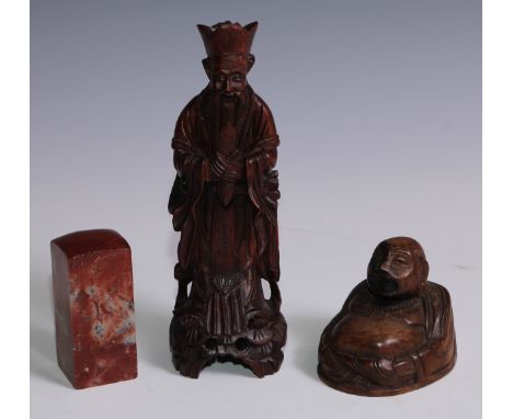 A Chinese soapstone seal, 9.5cm high; a Chinese carved hardwood figure, of an immortal, 23.5cm high; another, Budai, 8.5cm hi