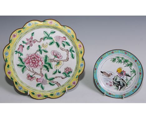 A Cantonese enamel shaped circular plate, painted in the famille rose palette with flowering branches, the border on a yellow