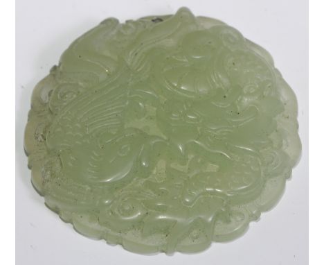 A Chinese jade pendant, carved with a dragon and a phoenix, 5cm diam 