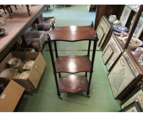 A Victorian three tier burr walnut and ebonised whatnot with turned finial decoration over brass cup castors, 97cm x 42cm x 2