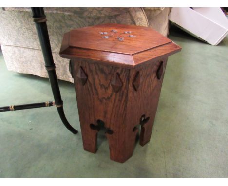 An Arts &amp; Crafts oak hexagonal top lamp table with clover leaf decoration, 37cm tall