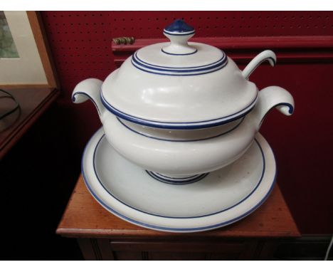 A large lidded soup tureen with ladle on stand