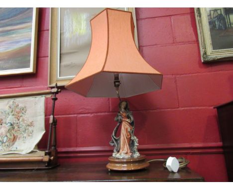 A figural table lamp, robed lady holding fruit, on stand with shade