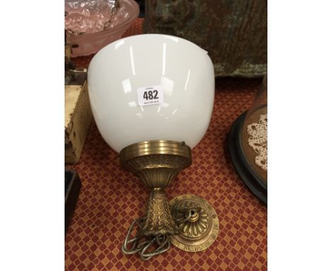 An Art Deco opaque white glass light shade on brass fitting.