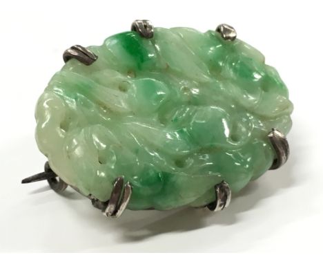 A white metal and carved jade panel brooch.