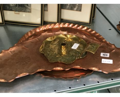 Two Arts & Crafts copper trays together with a brass chamber stick.