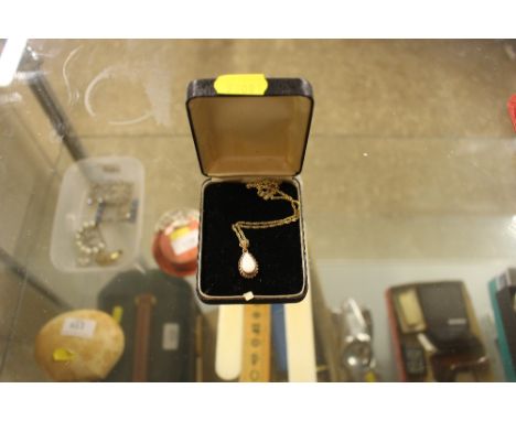 A 9ct gold chain hung to an opal set pendant 