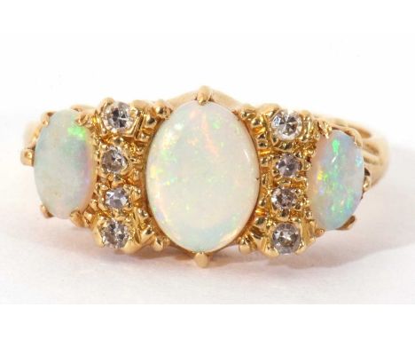18ct gold opal and diamond ring featuring three graduated oval shaped opals, highlighted between with eight small single cut 