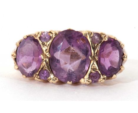 9ct gold three stone amethyst ring featuring three graduated oval facet cut amethysts highlighted with four small amethysts b