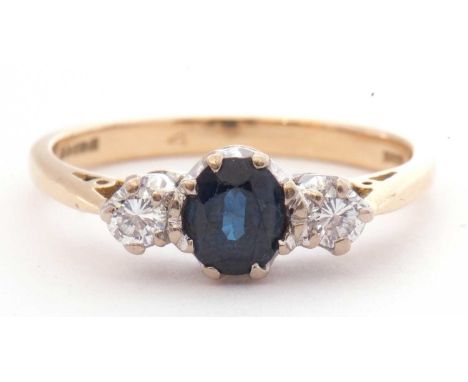 18ct gold sapphire and diamond three stone ring centring an oval faceted sapphire between two brilliant cut diamonds, 0.20ct 