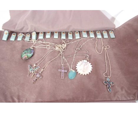Two leatherette rolls of jewellery to include 925 abalone shell mounted pendants, opal pendants etc