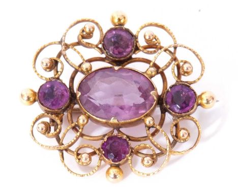 Yellow metal and amethyst brooch, the ornate scroll and bead openwork frame decorated with five graduated amethysts, 30 x 25m