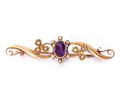 Amethyst and seed pearl scroll brooch centring an oval faceted amethyst in millegrain edge setting between floral buds and sc