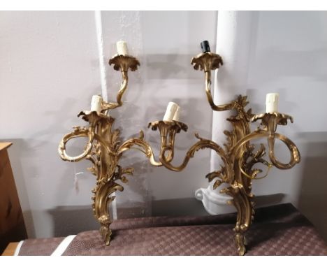 A pair of gilt metal three branch wall light fittings 