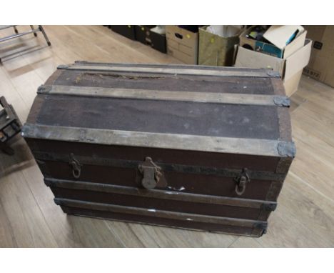 A vintage metal bound and dome topped trunk 