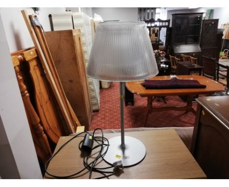 A grey coloured metal table lamp with glass shade