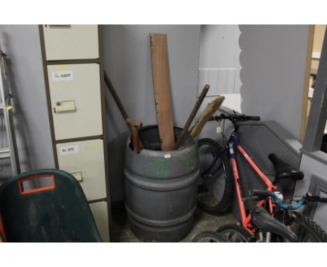A plastic water butt containing tools and brush