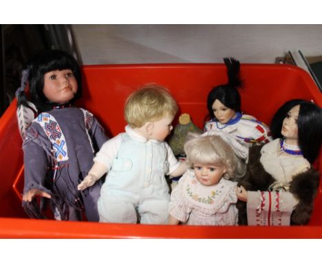 A box of vintage porcelain dolls and small rocking horse 