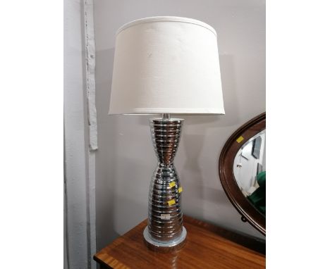 A ribbed metal table lamp with white coloured shade 