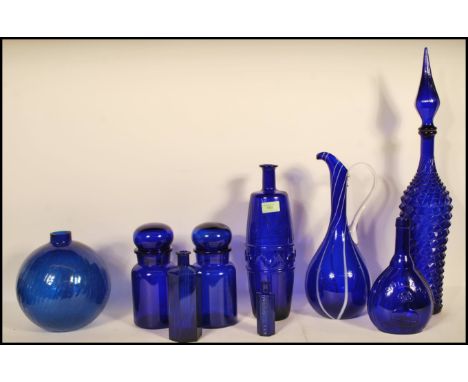 A collection of 20th Century blue glass items to include bulbous vase having a glazed effect, tall jug having white stripes t