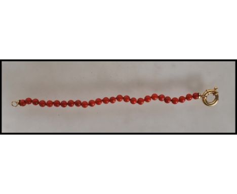 A Chinese 18ct gold and coral bracelet consisting of twenty six coral beads with a 18ct gold spring ring clasp. Unmarked but 