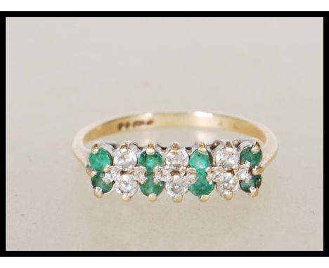 A 9ct gold English hallmarked ring set with two rows of alternate white and green stones. Hallmarked London 1988. Size K. Wei