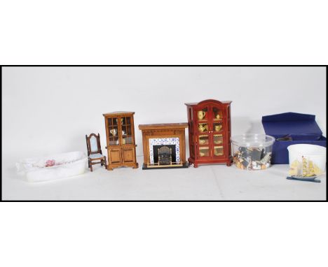 A good collection of assorted scale dolls house wares to include china cabinet, chair, fire place, books, candle sticks, corn