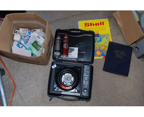 A portable gas stove, cylinders, electric lamp and road atlas.