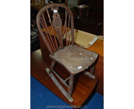 A Victorian stick and roundel backed rocking fireside armchair