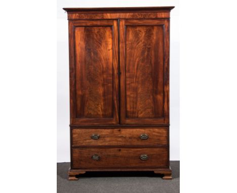 A George III mahogany linen press, cavetto moulded cornice and plain frieze, two panelled doors enclosing a hanging rail, two