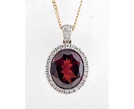 A garnet and diamond oval cluster pendant, the oval mixed cut garnet 11mm x 10mm, set in a 9 carat yellow and white gold moun