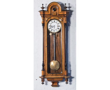 A walnut and ebonised Vienna wall clock, dome top pediment with urn finials, glazed door enclosing a white enamel dial, tripl