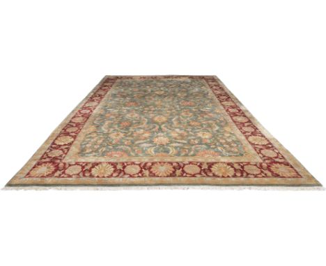 A large Tabriz style carpet, stylised floral decoration with scrolling tendrils on a pistachio field, border with guards, 625