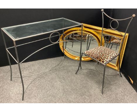 A contemporary wrought iron effect glass-top dressing or console table and chair, the table measuring 85cm high x 100cm wide 