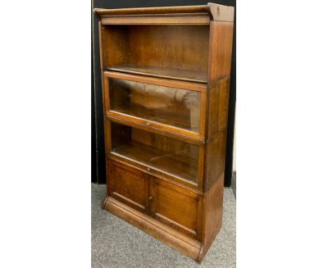 A Globe Werncke type oak four tier bookcase / cabinet, comprised of five sections - pediment, three bookcase sections (two wi