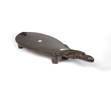 Oceanic art interest, a carved wood flat stool raised on four legs with bone inlay, 79cm long Provenance: From the collection