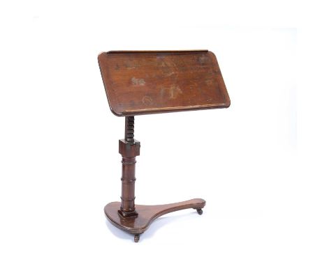 A mid Victorian mahogany reading table, with rectangular adjustable top, on ring turned side column and shaped platform base,