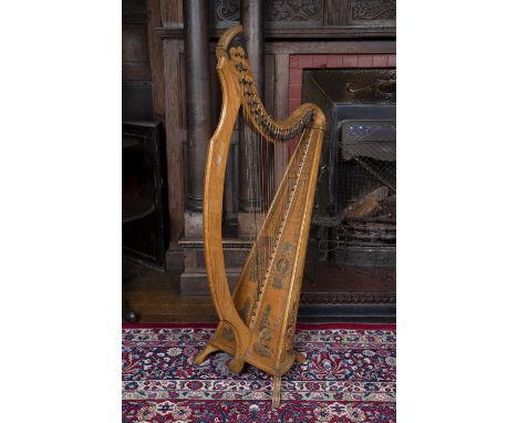 An Irish Arts & Crafts Celtic revival beechwood and elm harp, by James McFall, Belfast, having twenty eight strings, carved a