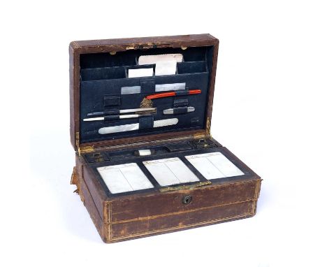 A Victorian leather dispatch and writing case, the fitted interior with ceramic diary tablets, ink bottle and lighters by Tou
