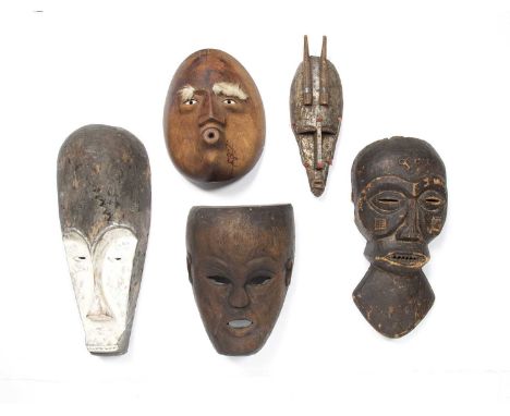 Tribal interest, a group of five masks, all carved wood including a fang mask with white pigments and a small Bambara mask, 4