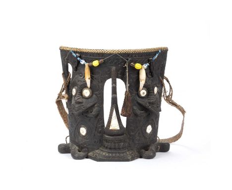 A Dayak ceremonial carved wood baby carrier, Borneo, with ancestor figures, inlaid shells and applied strung beads, with carr