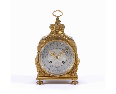 A 19th century French gilt brass travelling clock, the shaped top with hinged loop handle, the case with stylised foliate wre