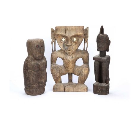 Tribal interest, Dayak Hampatong Borneo carved wooden figure, the standing male figure with hands to his knees and inlay bone