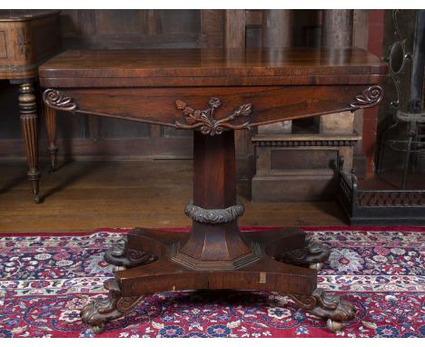 An early Victorian rosewood fold over top card table with foliate carved octagonal column, concave sided platform base, and c