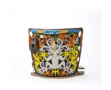Tribal interest, A Dayak baby carrier, Borneo, the woven cane body with an applied beadwork panel depicting an ancestor figur