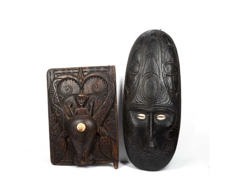 A large oceanic ancestor mask from Papua New Guinea, carved wood with cowrie eyes, 81cm long, together with a carved wooden I