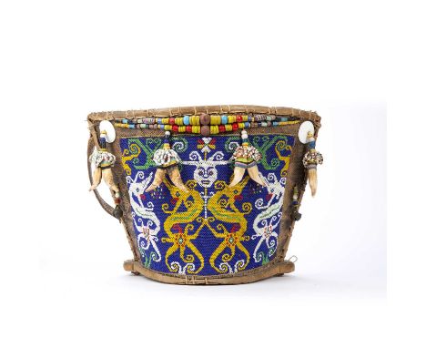 Tribal interest, A Dayak baby carrier, Borneo, the woven cane body with an applied beadwork blue ground panel decorated head 